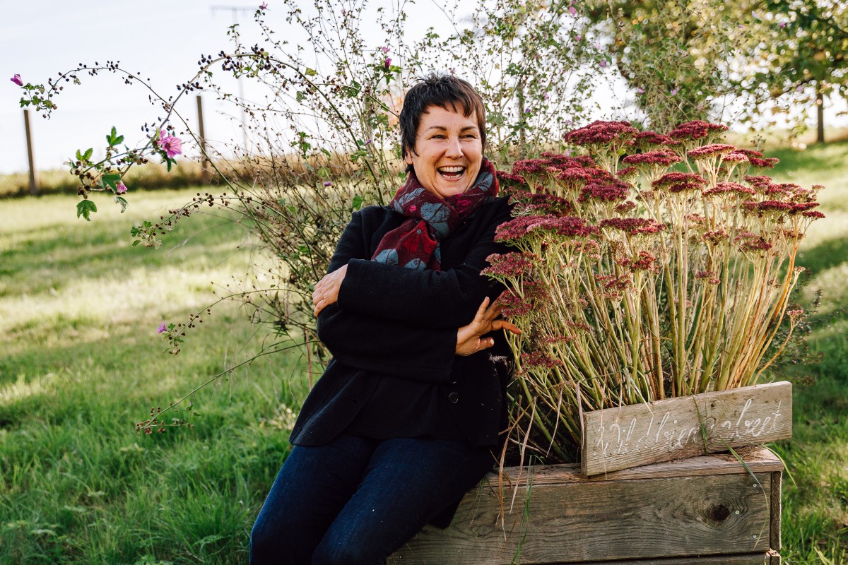 Ulrike Gschwendtner sitzt neben Herbststauden