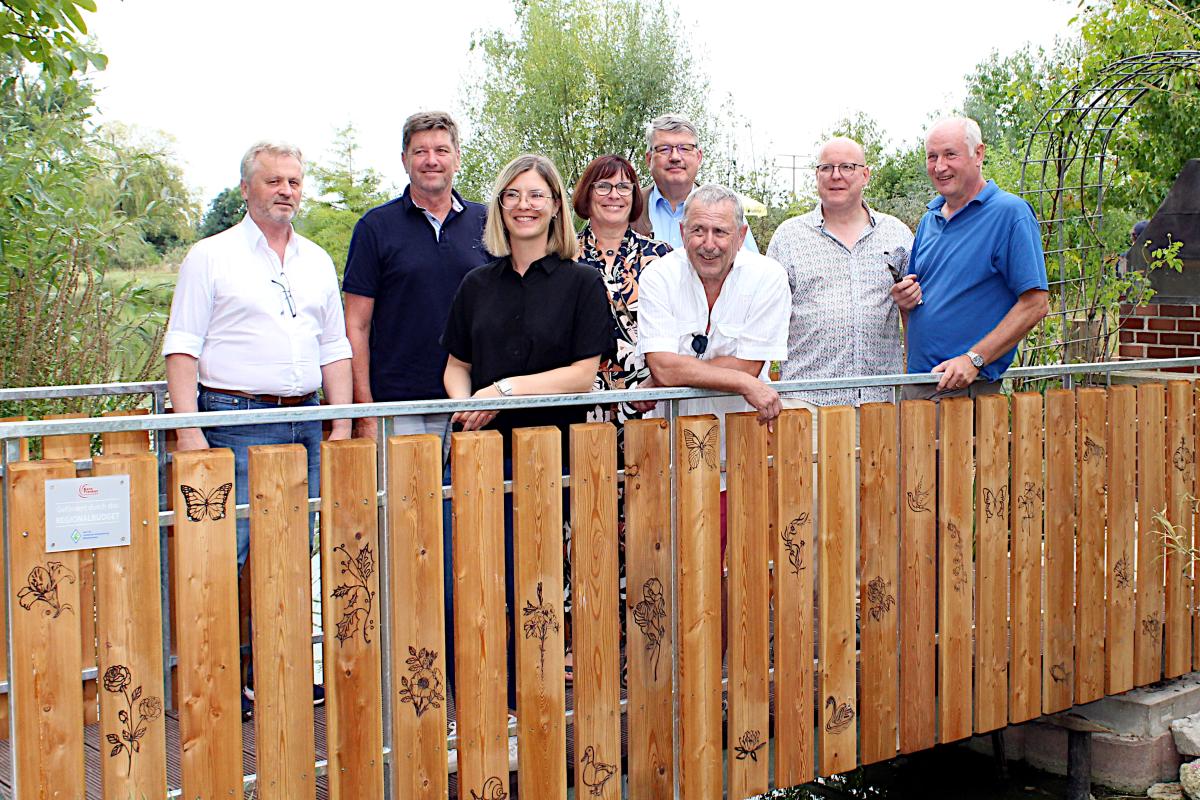 Zwei Frauen und sechs Männer haben im Schau- und Lehrgarten in Petersaurach eine neue Brücke aus Holz eingeweiht.